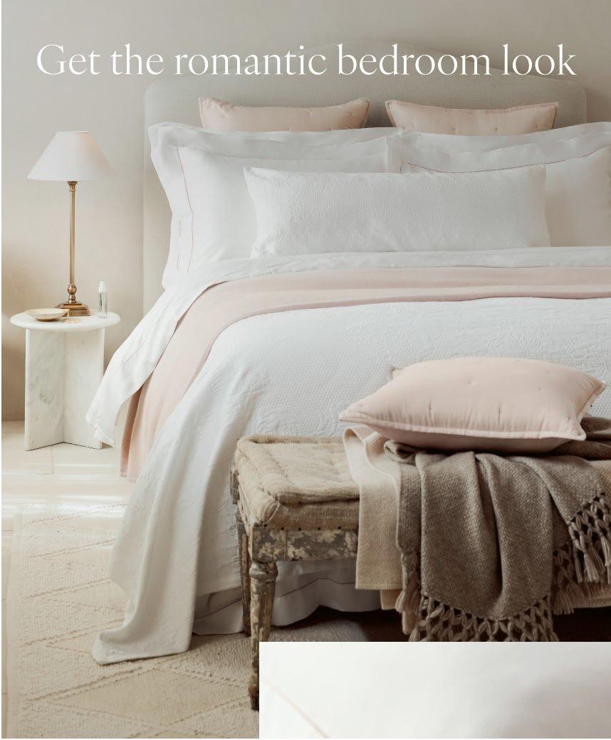 a bedroom with a bed, a nightstand and a lamp