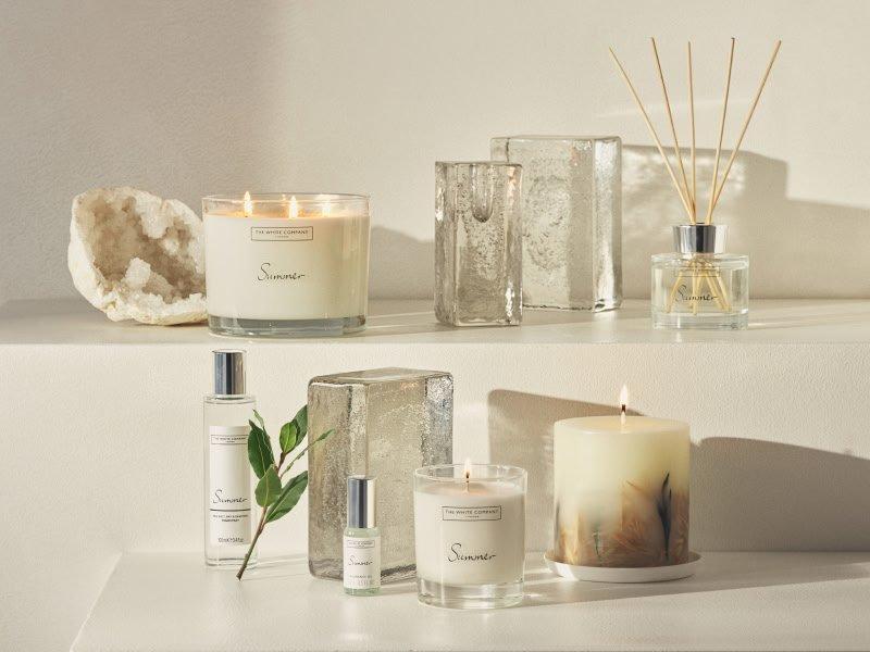 a collection of candles and other items are displayed on shelves