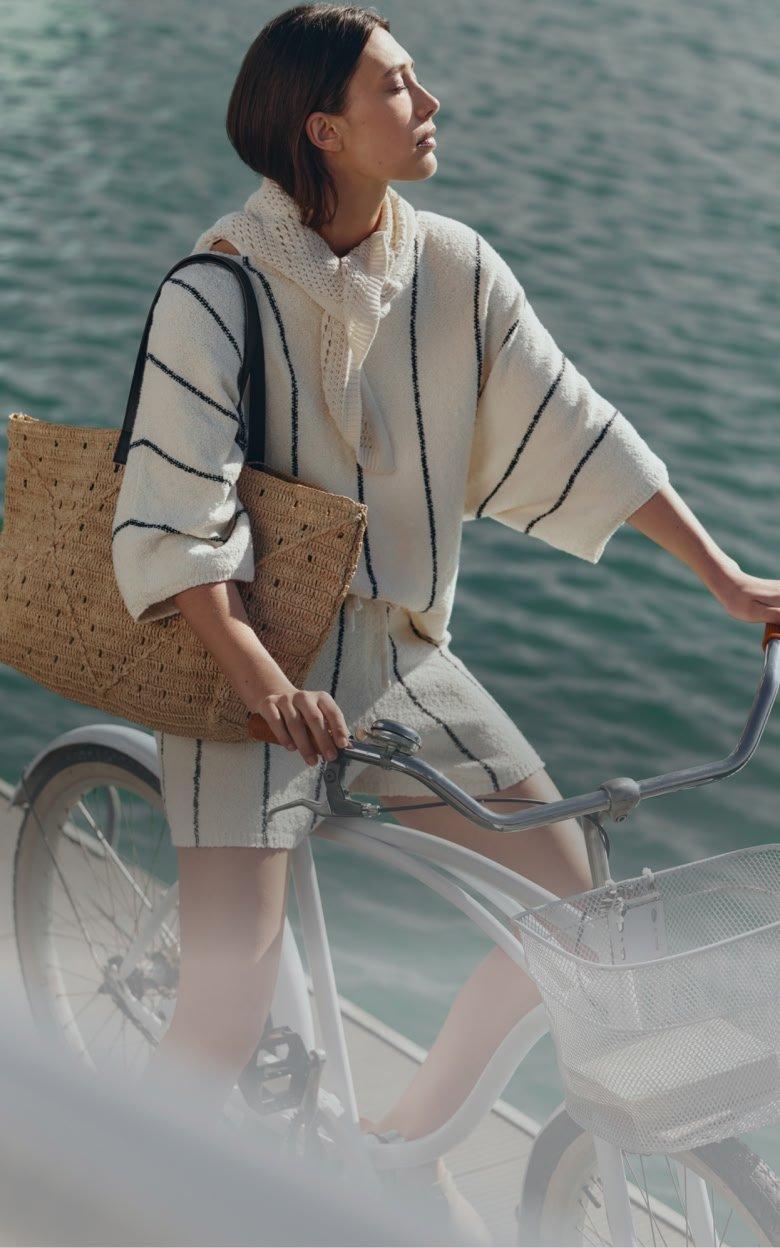 a woman riding a bike with a basket on the front
