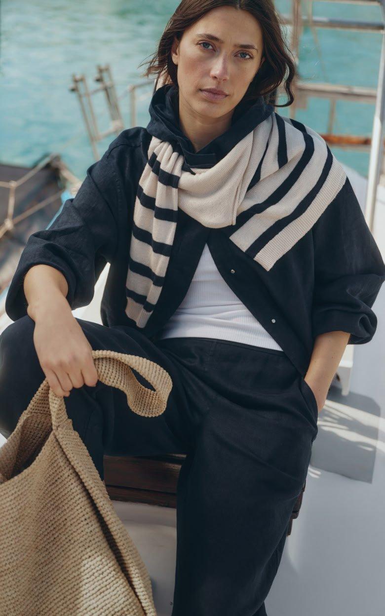 a woman sitting on a boat with a bag on her lap