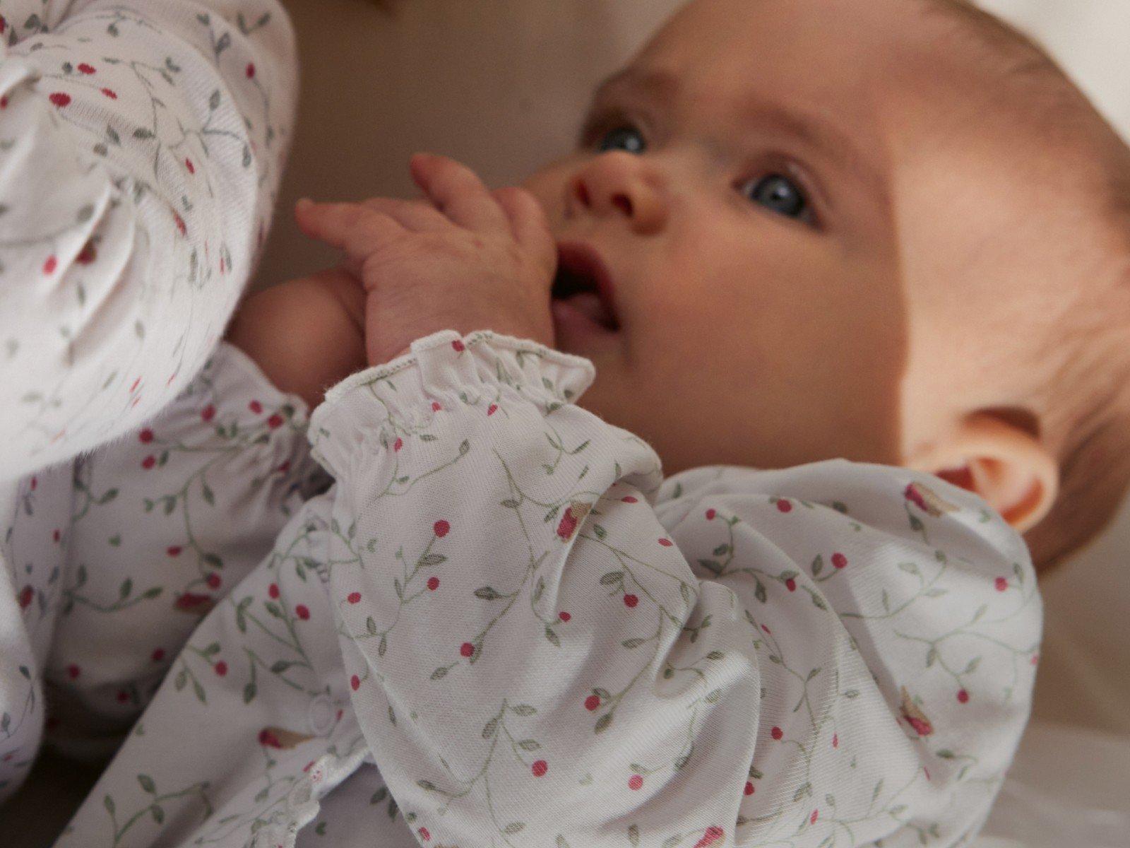 a baby in pajamas with a blanket on its head