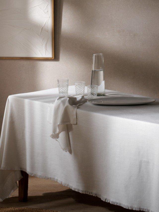 a table with a white cloth and a glass on it