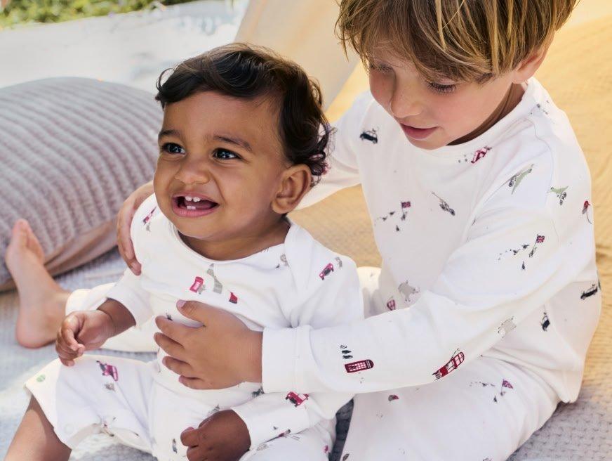 two children are playing with each other on a bed