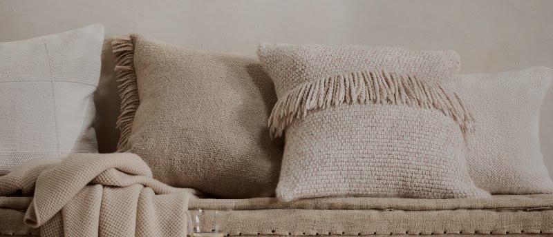 a bench with pillows and a glass of wine on it