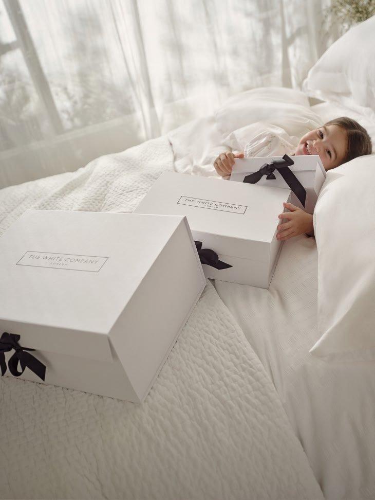 a white paper bag with a black bow sitting on a table