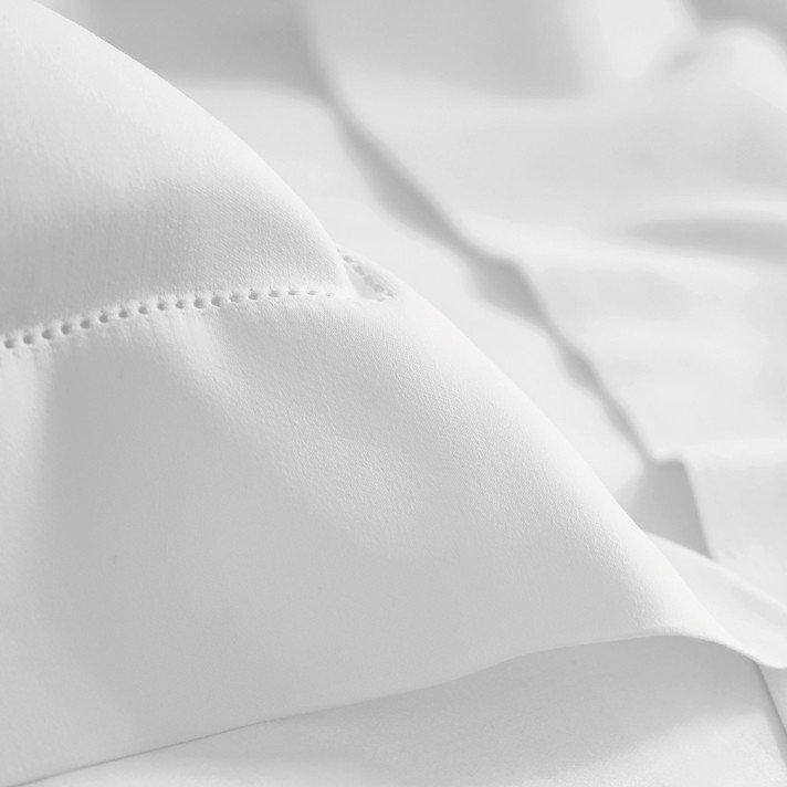 a close up of a white sheet with a small stitch