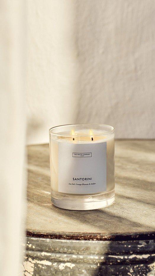 a candle sitting on top of a table on a wooden surface