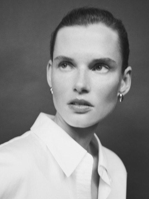 a woman in a white shirt with a big earring