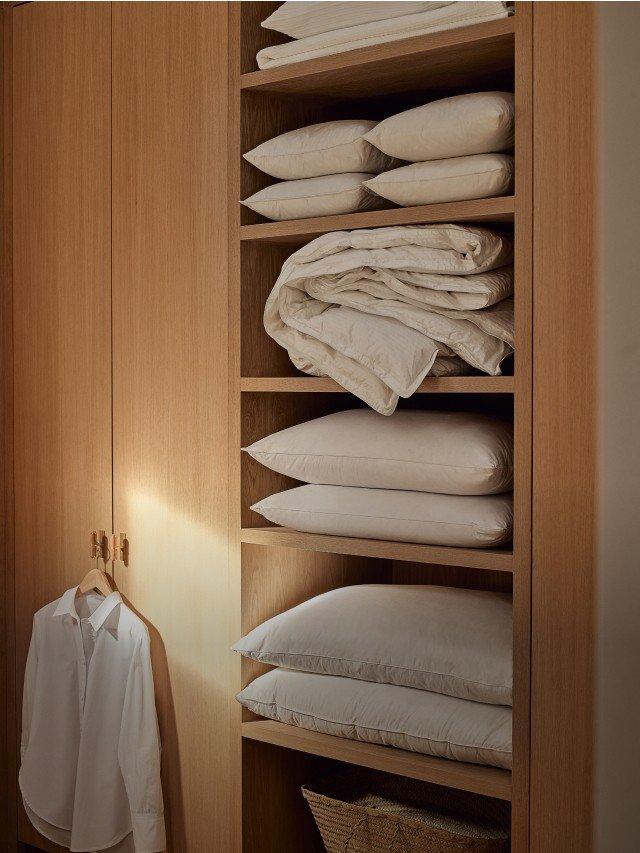 a shelf with a bunch of pillows and a blanket on it