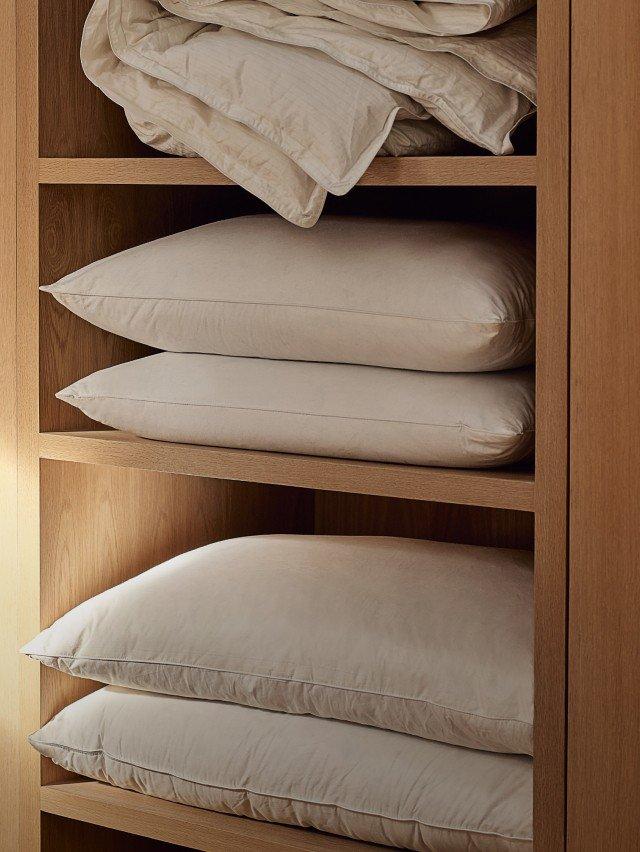 a shelf with a bunch of pillows and a blanket on it