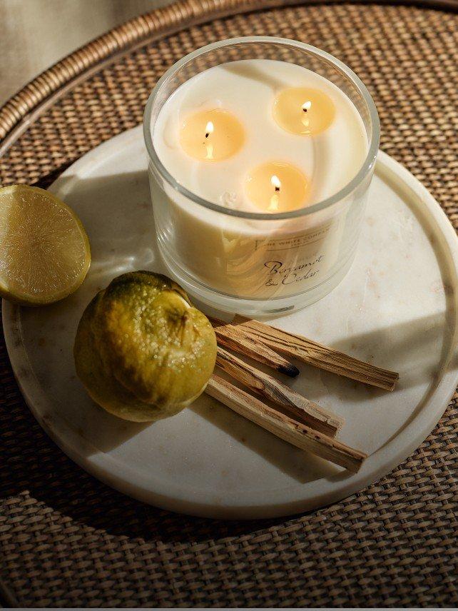 a candle on a plate with a lemon and a stick