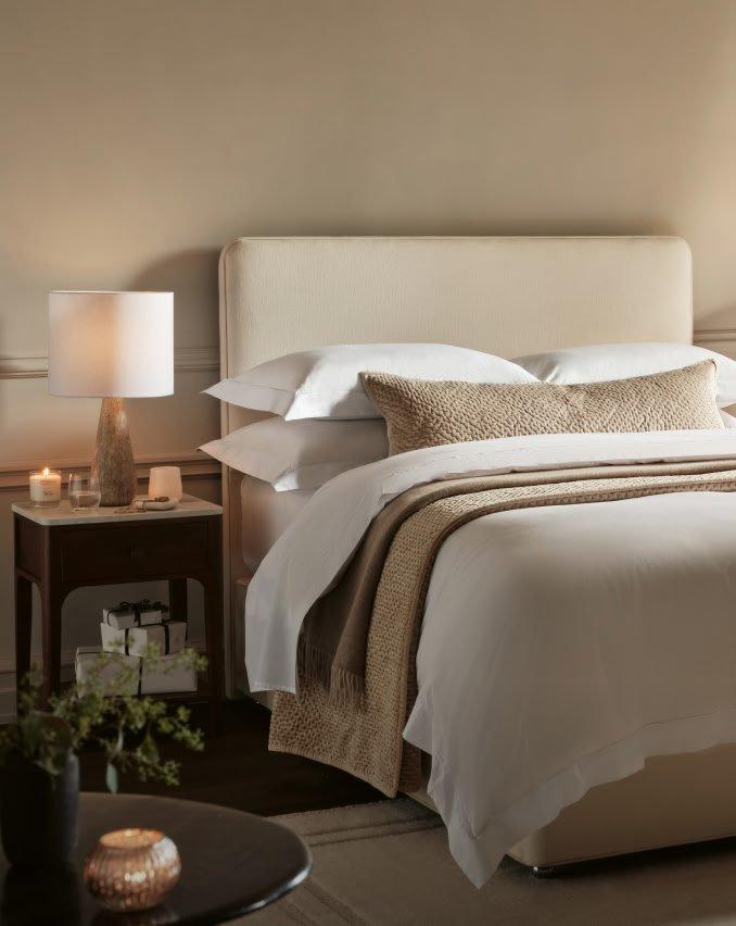 a bedroom with a bed, nightstands, and a lamp