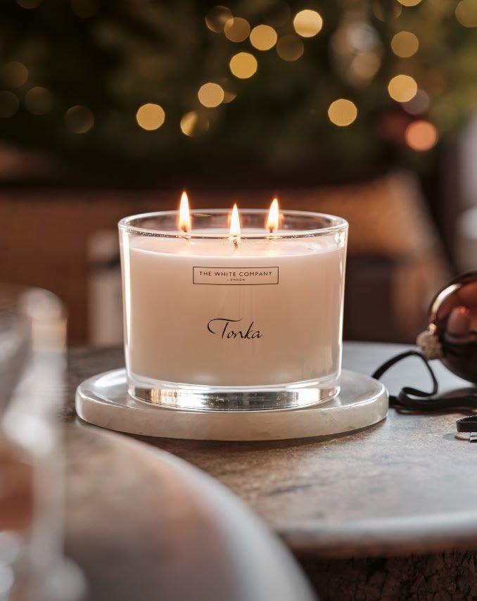 a candle sits on a table next to a glass ornament