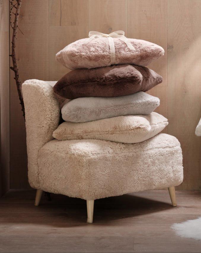 a pile of pillows on a chair in a room with a yellow ball
