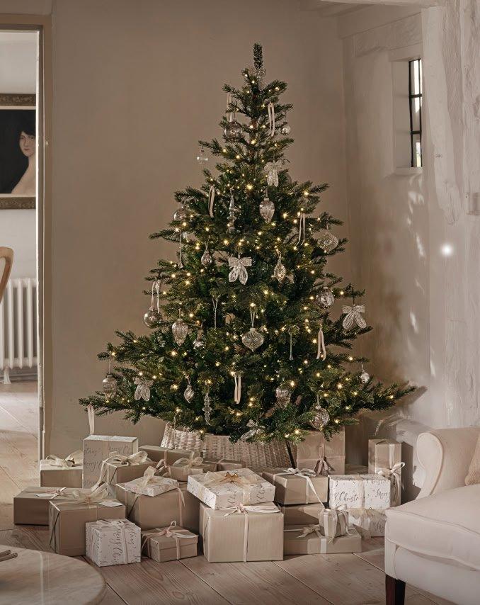 a christmas tree in a living room with presents underneath it