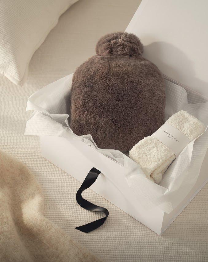 a white box with a fuzzy hat and a pair of socks