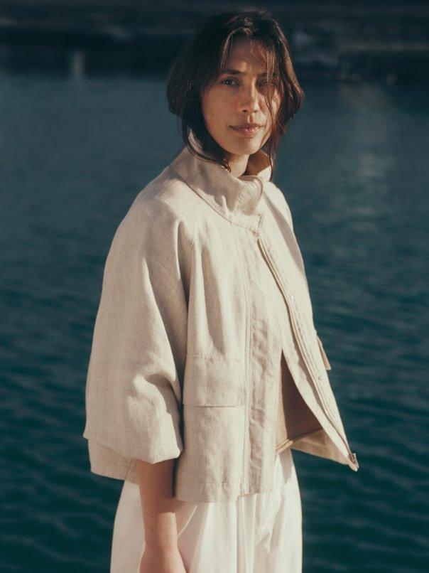 a woman standing on a dock in front of a body of water
