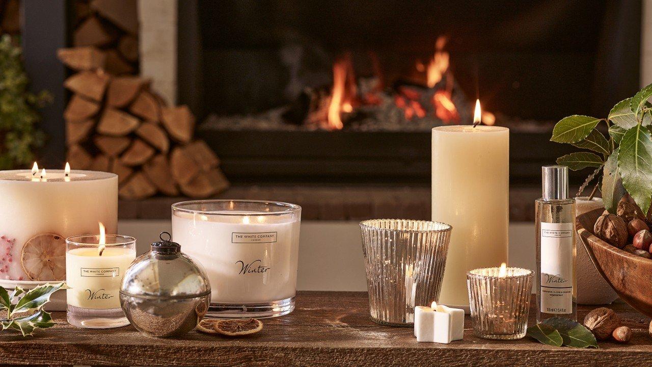 a table with candles and other items on it in front of a fireplace