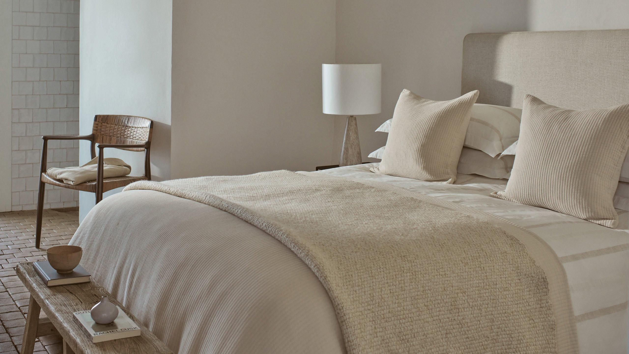 a bedroom with a bed, chair, and a window with a view