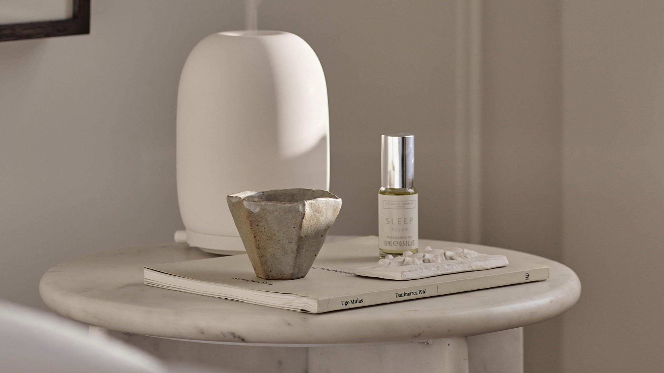a white robe and slippers on a table with a box of chocolates