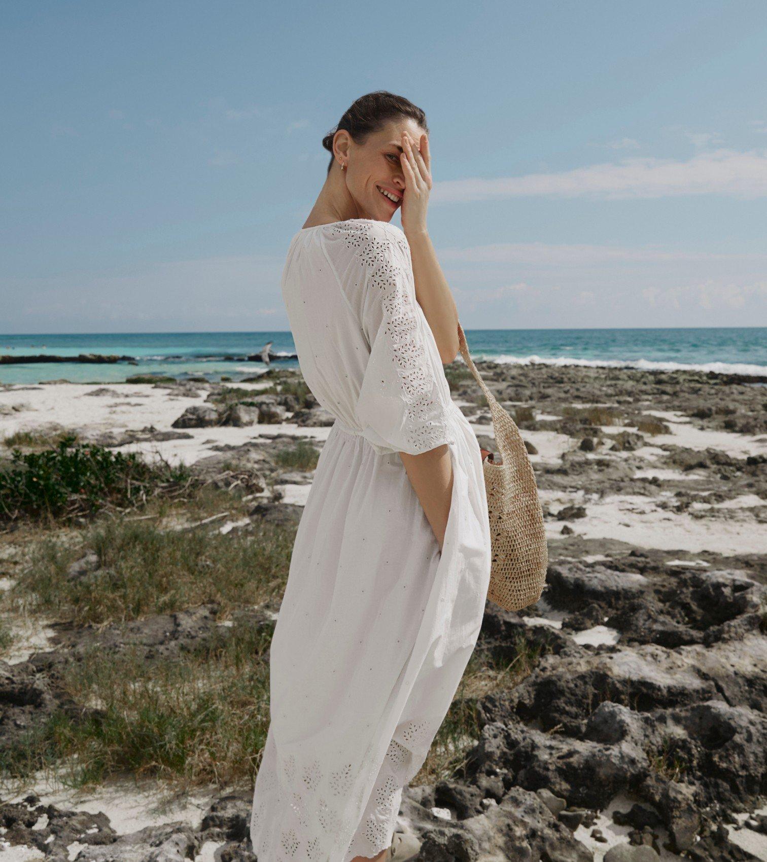 a woman standing on the shore of a body of water