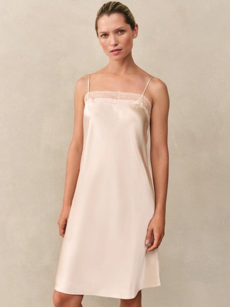 a woman in a white slip dress posing for a photo