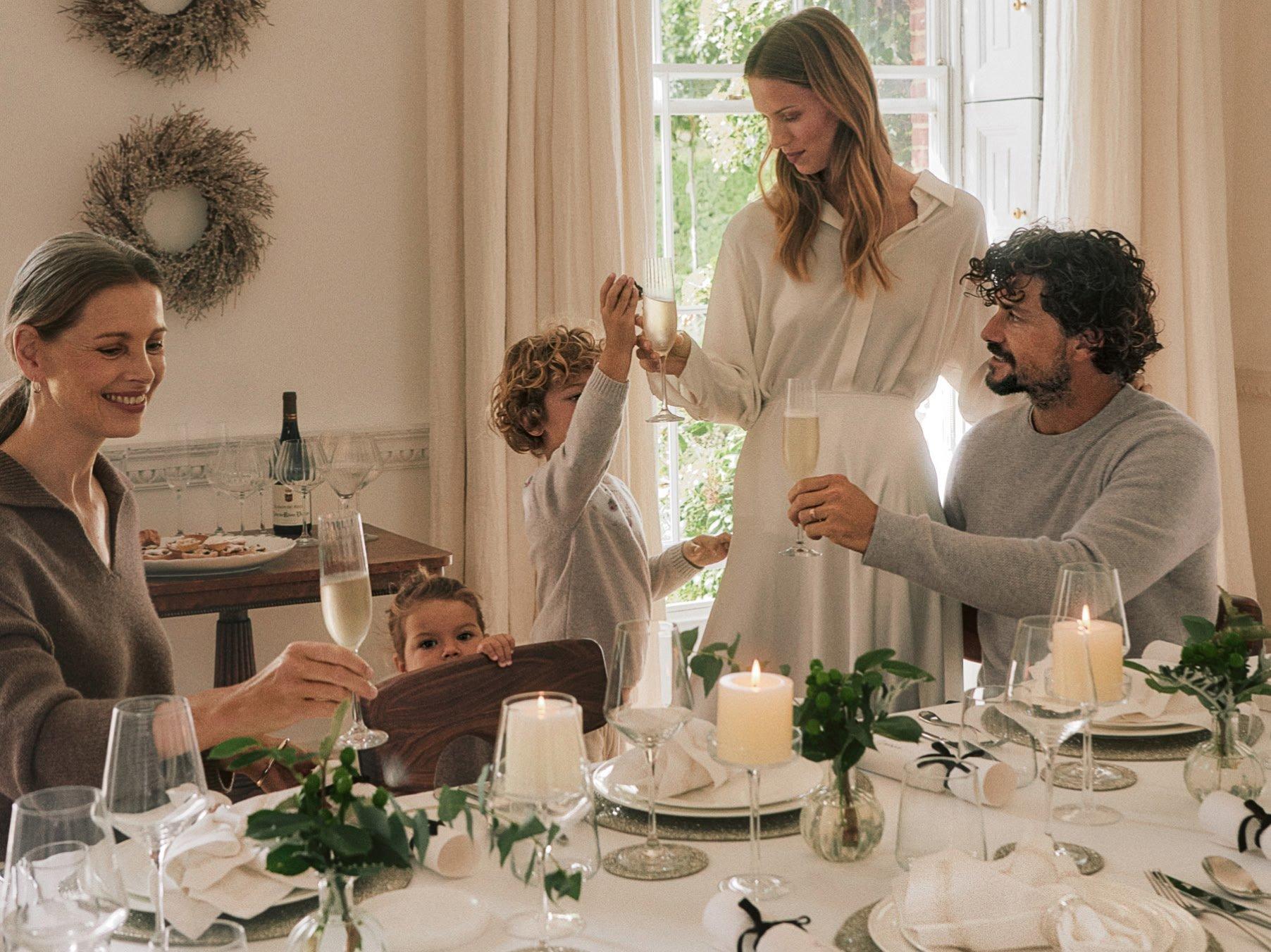 a family of people sitting at a table toasting each other
