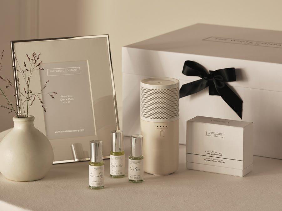 a white box with a picture frame and a vase on a table