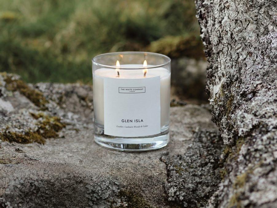 a candle sitting on a rock in the middle of a forest
