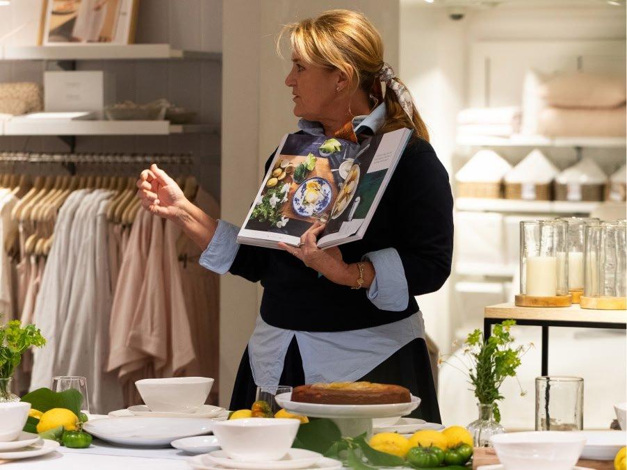 a woman standing in a room with a book open on a table
