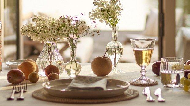 a table with a vase of flowers and fruit on it