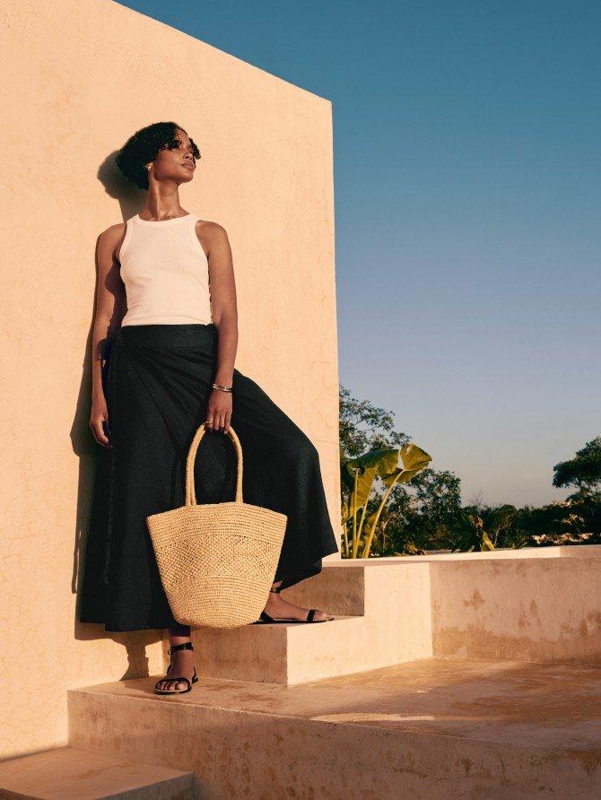a woman standing on a set of stairs holding a bag