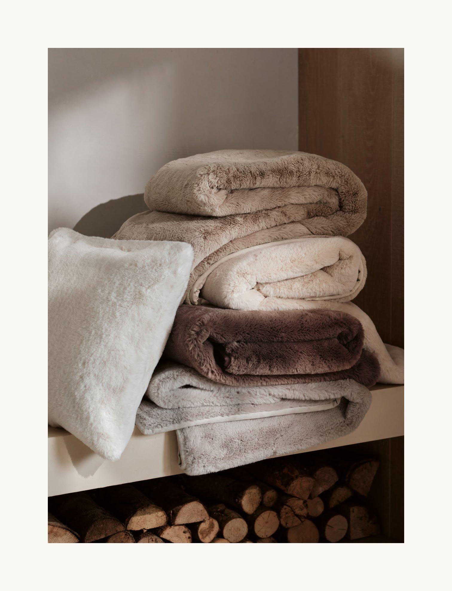 a stack of towels on a shelf next to logs