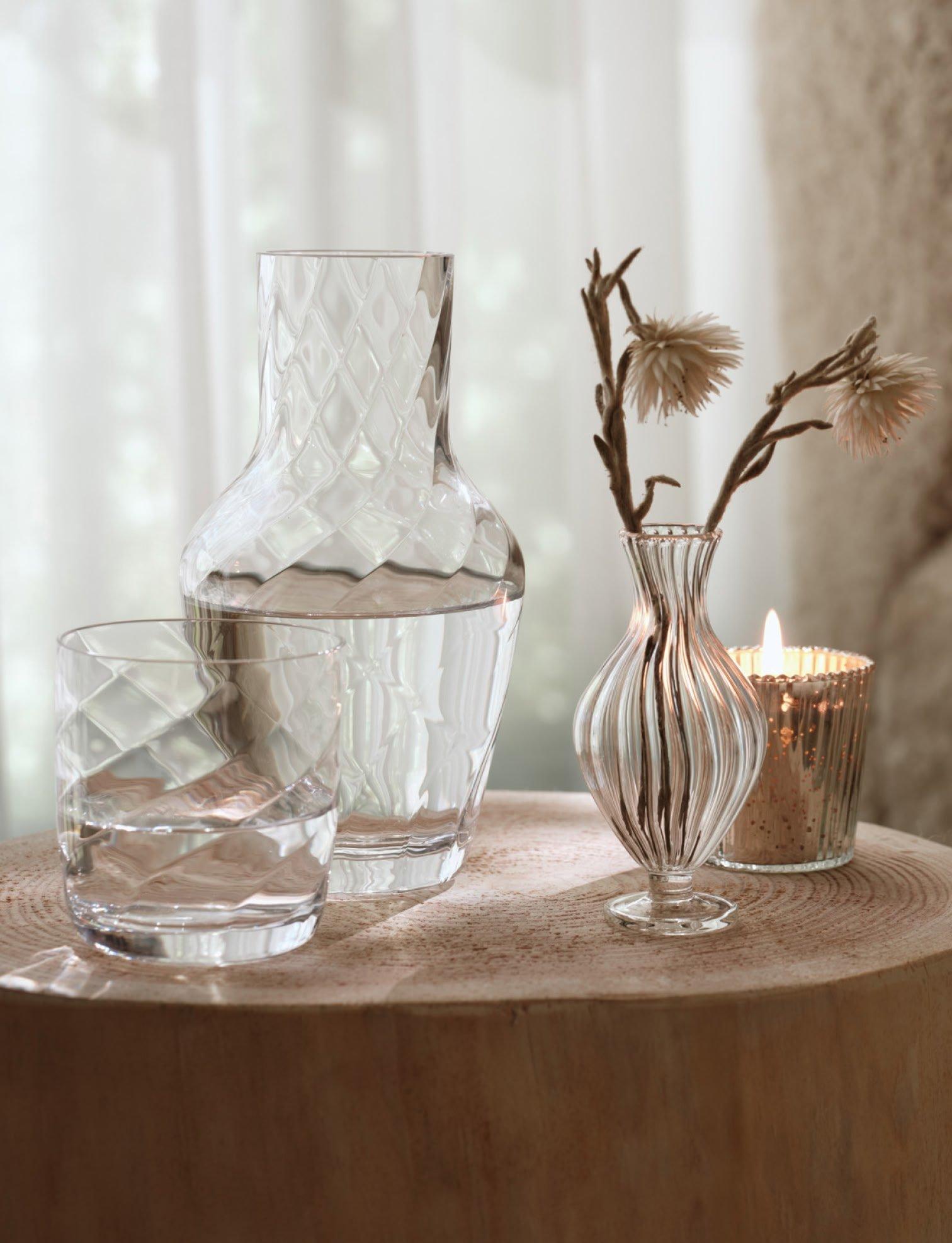 a table with three vases and a candle on it