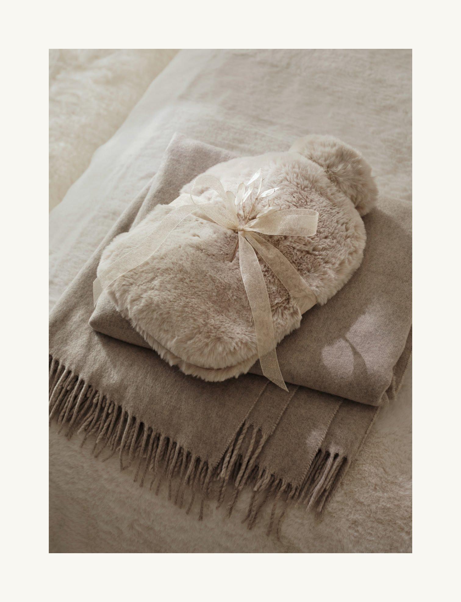 a blanket with a bow on it sitting on top of a bed