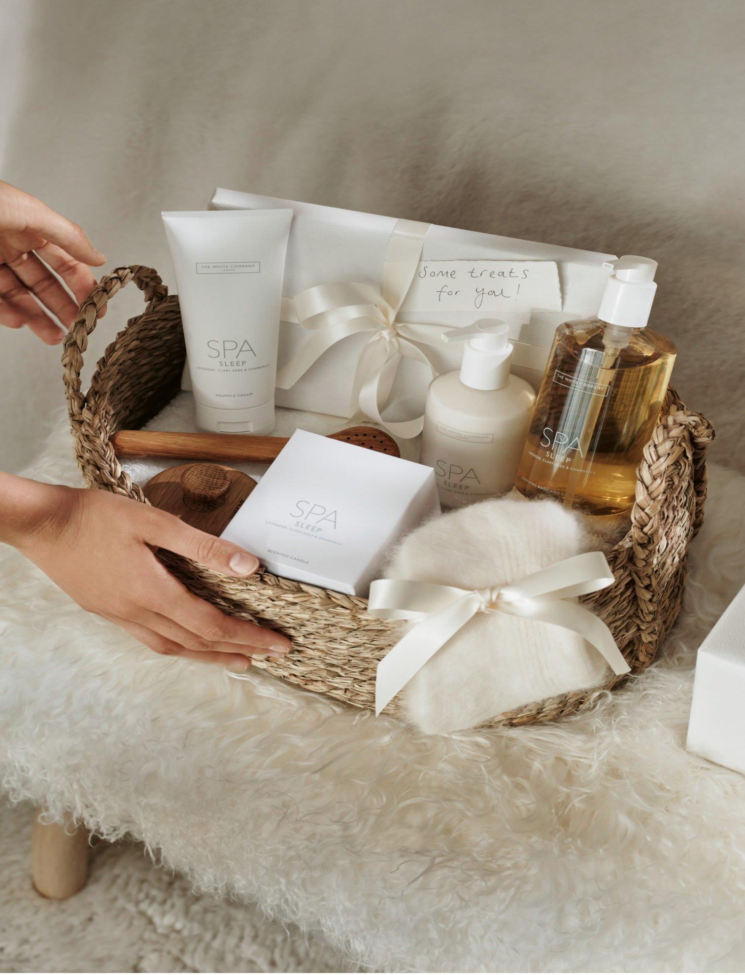 a person is holding a basket of items on a white table