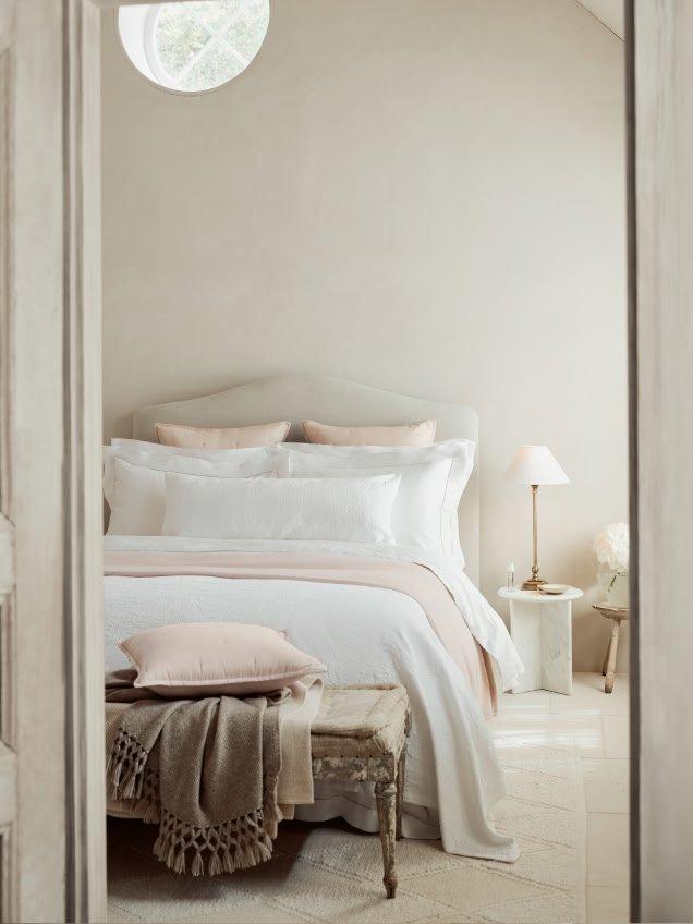 a bedroom with a bed, a chair and a window