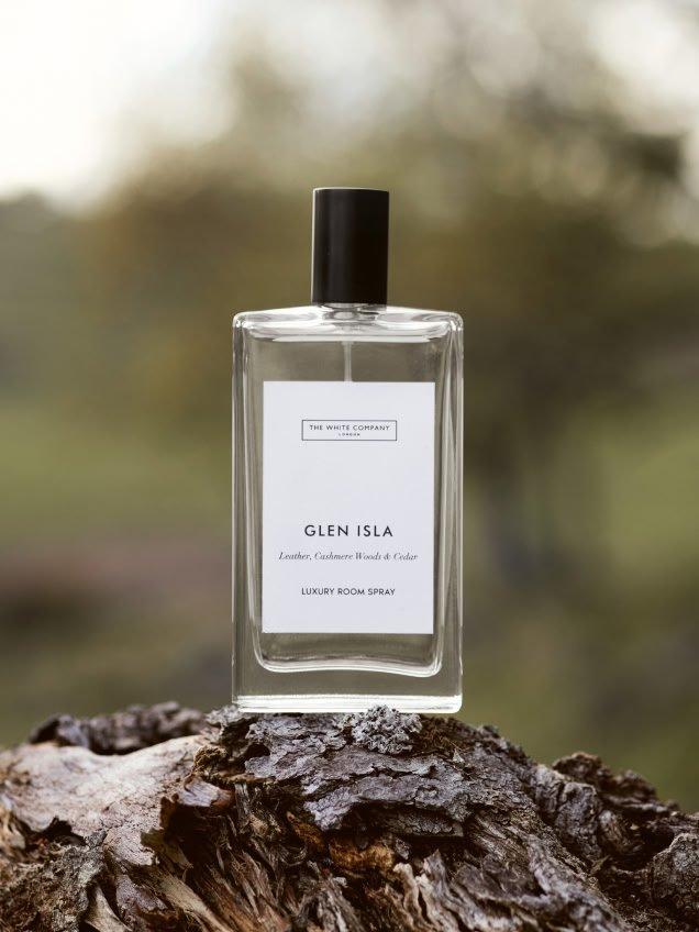 a bottle of perfume sitting on top of a tree stump