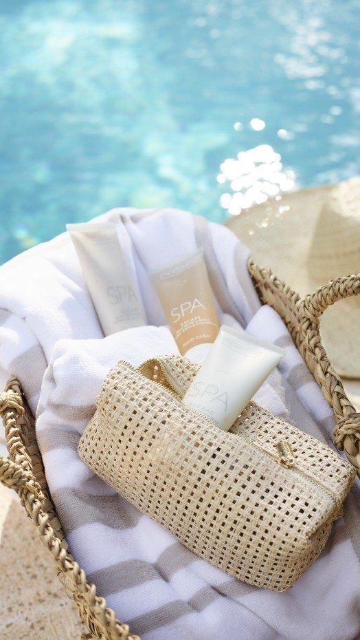 a basket with a towel and some other items near a pool
