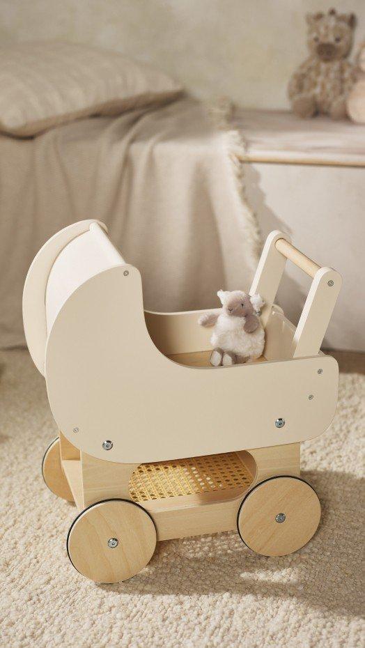 a small white toy carriage with a stuffed animal inside