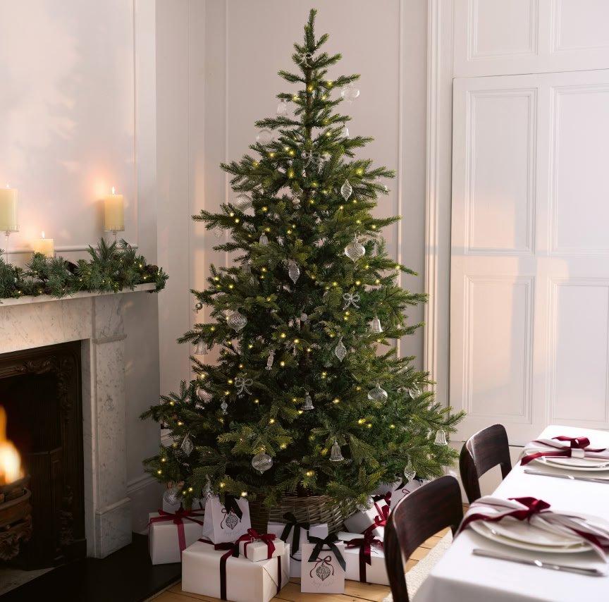 a christmas tree is in a room with a fireplace