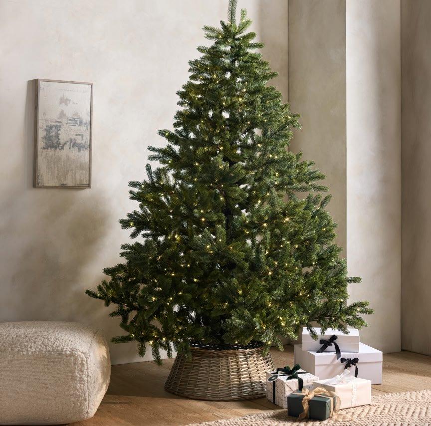 a christmas tree in a basket next to presents