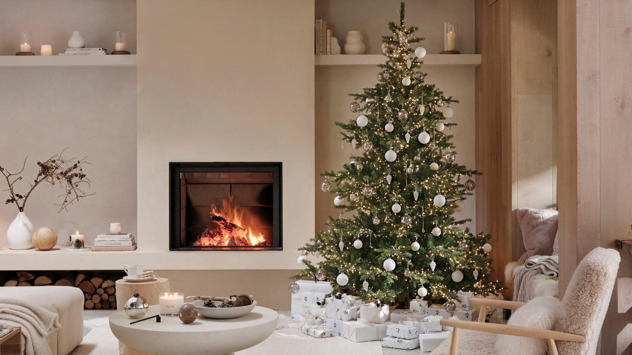 a living room with a fireplace and a christmas tree