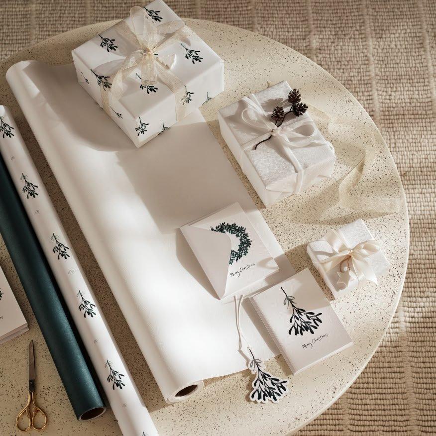a table with wrapping paper, scissors and a box of tissue