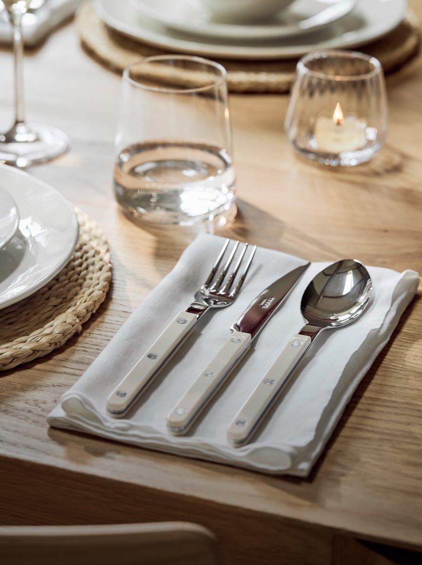 a table setting with a white cloth and silverware on it