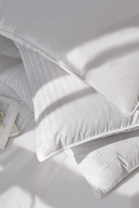 a close up of a pile of white pillows on a bed