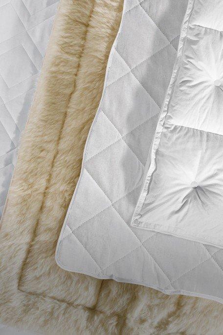 a close up of a white quilt and a white fur blanket