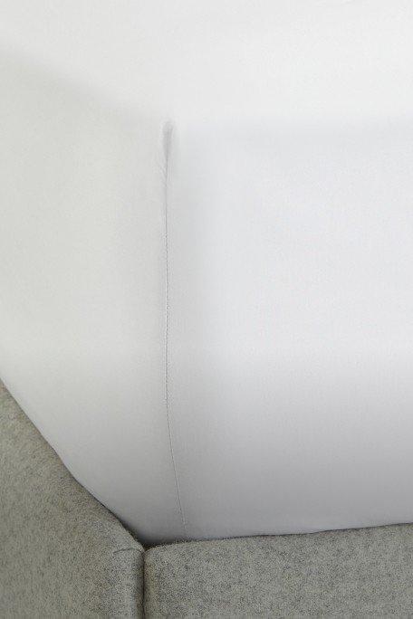 a close up of a white bed with a white sheet