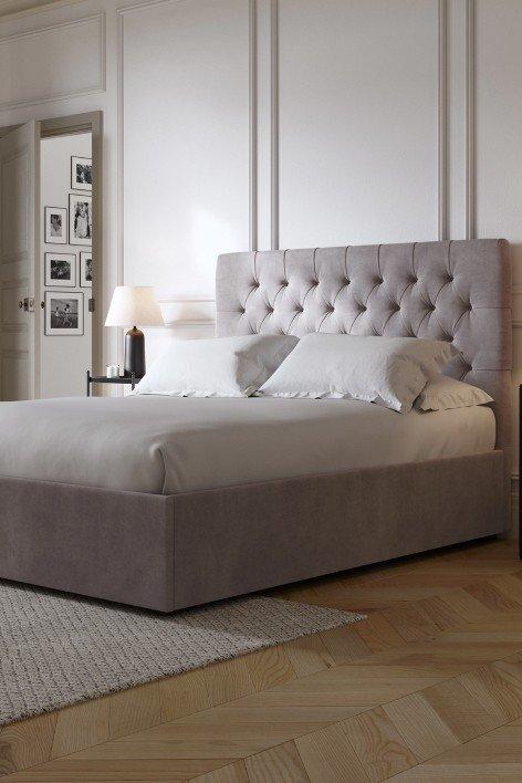 a bed with a white headboard and footboard in a bedroom