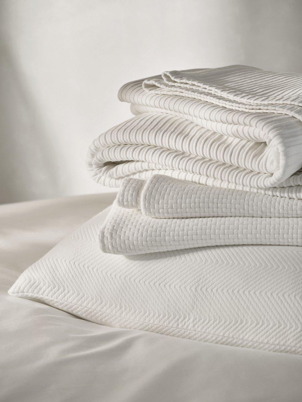 a stack of white towels on a bed